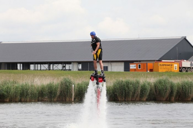 hombre practicando flyboard con vegetacion de fondo